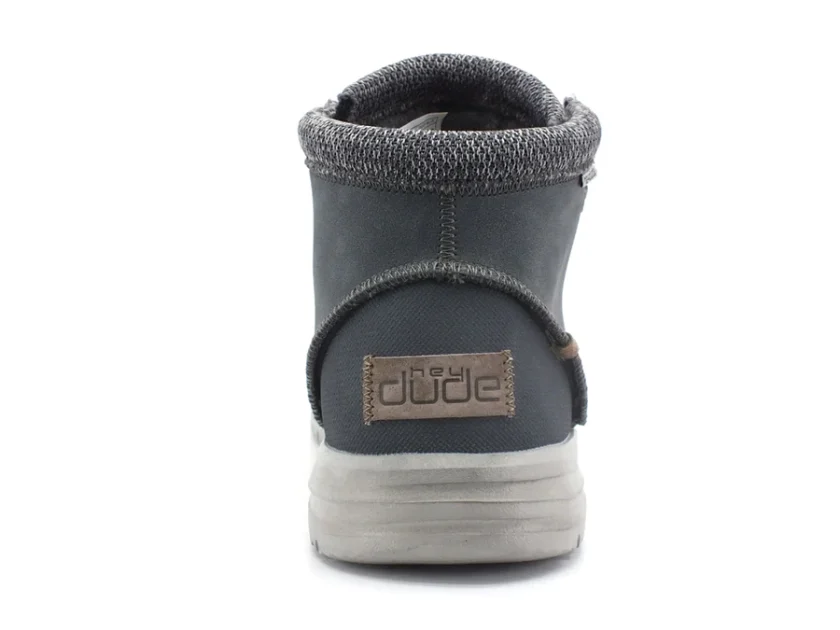"Rear view of a Heydude 113302623 black ankle boot with gray knitted collar and a beige Heydude logo patch on the heel above a light gray sole."
