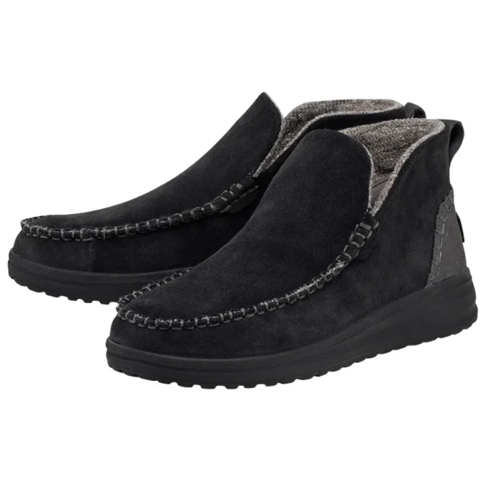"Angled view of a pair of black Hey Dude men's shoes, model 122034900, showcasing the moccasin-style suede upper, visible stitching, and soft gray fleece lining."