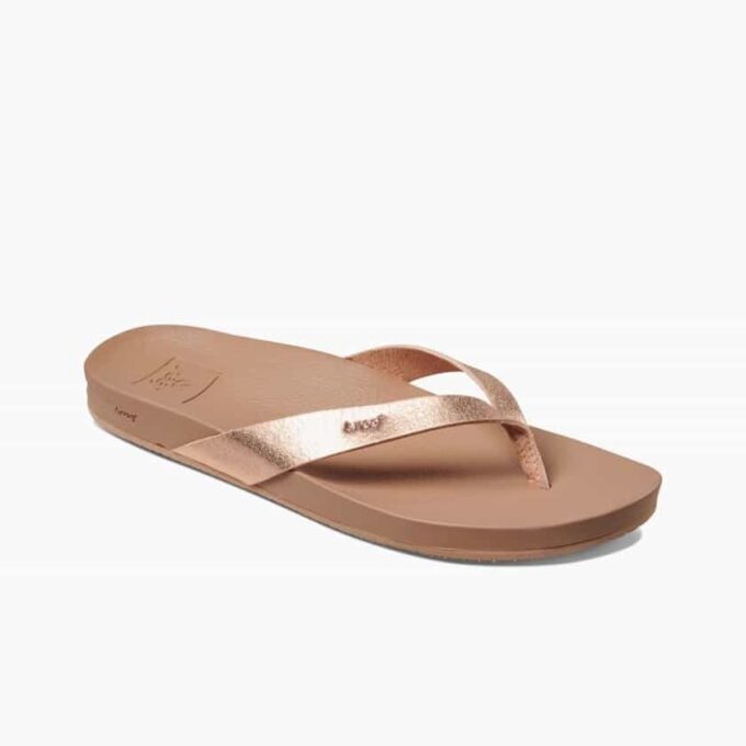 "Angled side view of Reef RF0A3FDSRGL women's sandal featuring a tan footbed and metallic rose gold straps with embossed Reef branding on the side."