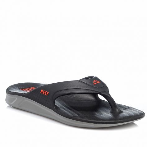 "Angled front view of a black and gray Reef RF0A3ONCGOR flip-flop sandal with red Reef logo accents and a contoured textured footbed."