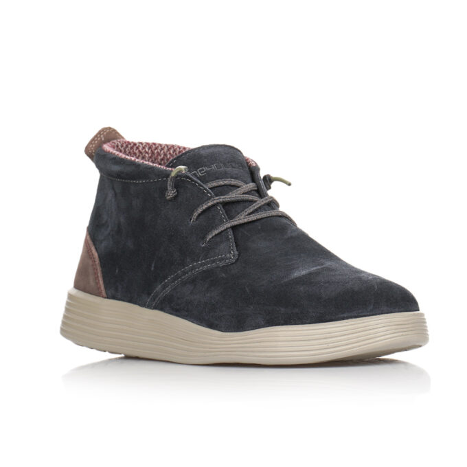 "Angled front view of Hey Dude men's shoe, model 112372680, showcasing dark navy suede upper, tan leather heel accent, beige textured outsole, and lace-up closure with contrasting patterned inner lining."