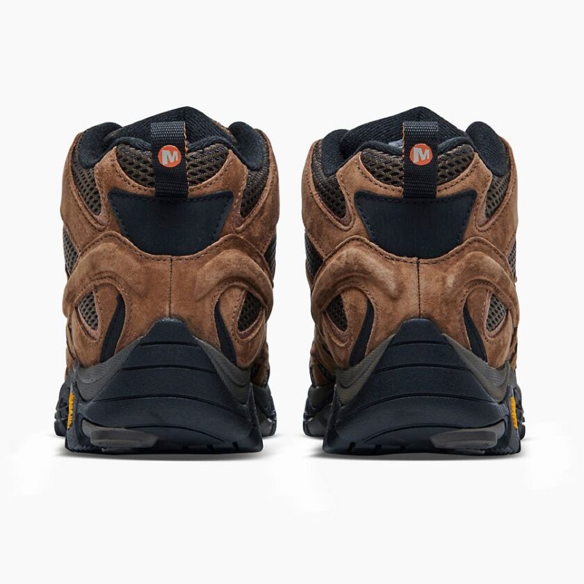 "Rear view of a pair of brown Merrell J06051 hiking boots with black soles and black mesh panels, featuring pull tabs with an orange "M" logo."