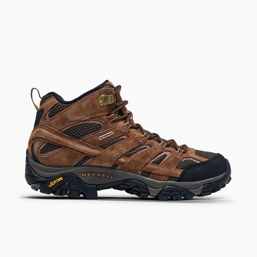 "Side view of a brown Merrell J06051 hiking boot with black and orange laces, black toe cap, and rugged black and grey Vibram outsole, showing a "Waterproof" label on the side."