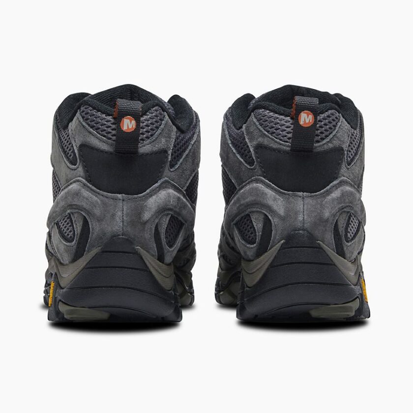 "Rear view of a pair of Merrell J06053 hiking shoes in dark gray with black and orange accents, showing the padded heel collars, mesh and suede upper construction, black midsoles, and Vibram outsoles with a small orange logo on each shoe against a white background."