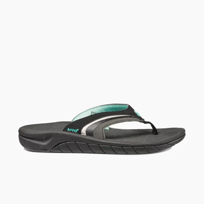 “Side view of a Reef RF001084BKQ flip-flop sandal in black with teal and gray accents, featuring a contoured footbed and textured sole.”