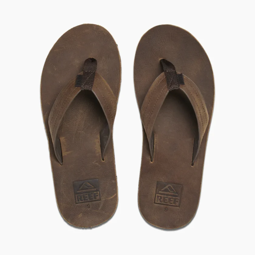 "Top view of brown Reef RF0A2YFRDAB flip-flops with thick straps and embossed REEF logo near the heel."