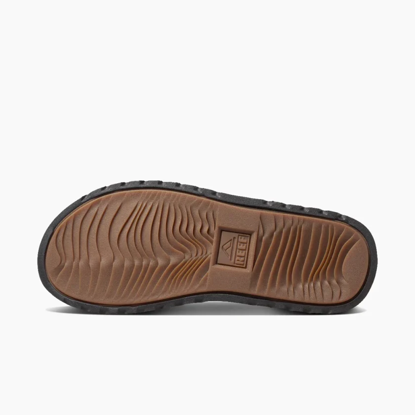"Bottom view of Reef RF0A2YFRDAB shoe showing brown rubber sole with textured grip and REEF logo embossed in the center."