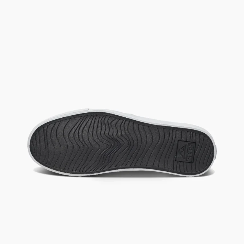 "Bottom view of Reef RF0A3FE4BLW shoe showing black rubber outsole with wave-like tread pattern and embossed Reef logo near the heel."