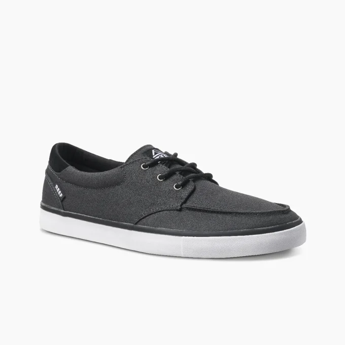 "Angled side view of Reef RF0A3FE4BLW men's casual black canvas shoe with white sole and black laces."