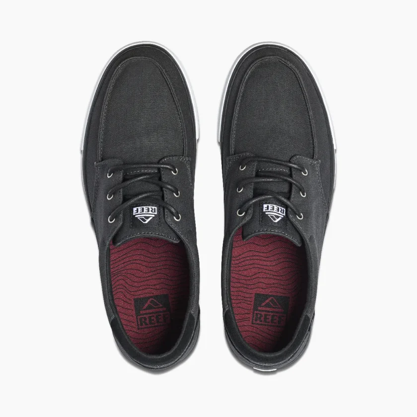 "Top view of Reef RF0A3FE4BLW shoes in black with white stitching, black laces, and maroon insoles featuring a wave pattern and Reef logo."