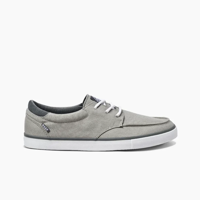"Side view of Reef RF0A3FE4GRW casual sneaker in gray canvas with white laces, black trim, and white rubber outsole featuring the Reef logo tag near the heel."
