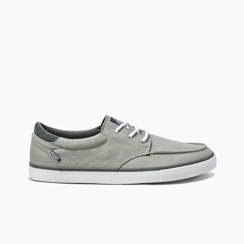 "Side view of Reef RF0A3FE4GRW casual sneaker in gray canvas with white laces, black trim, and white rubber outsole featuring the Reef logo tag near the heel."