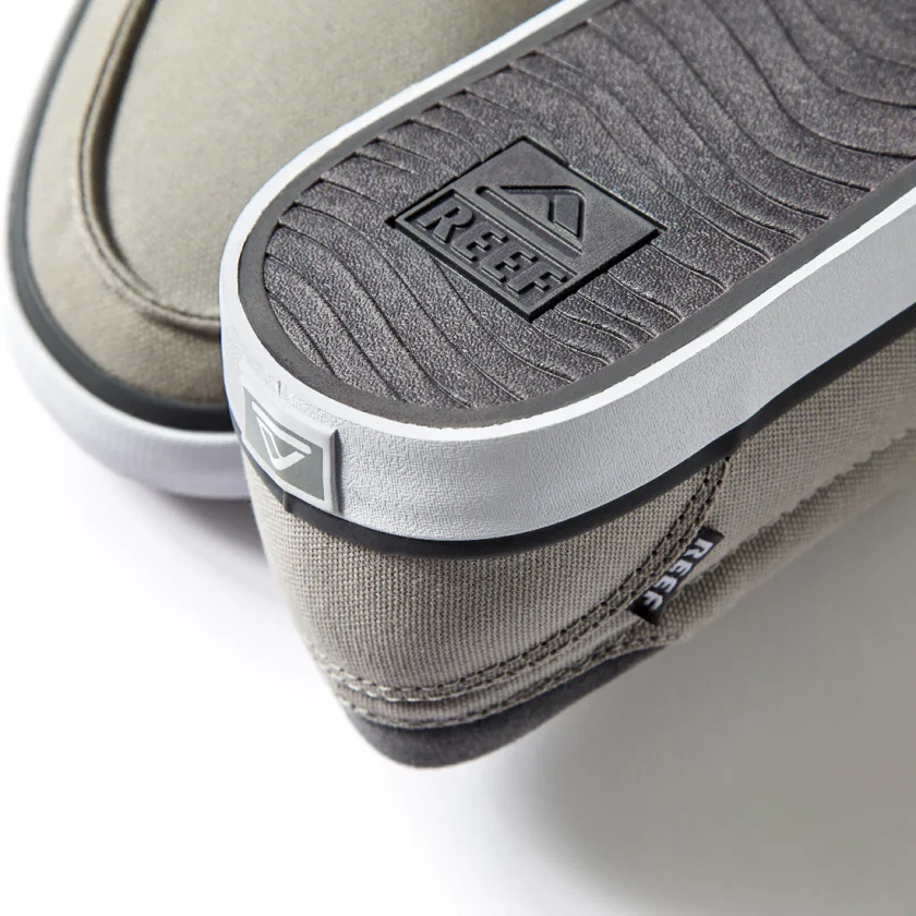 "Close-up rear view of Reef RF0A3FE4GRW shoe showing the textured gray outsole with embossed Reef logo, gray canvas upper, and branded heel tag detail."