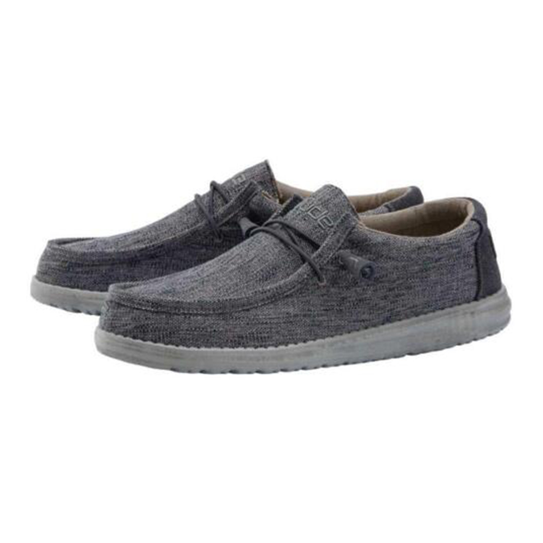 "Pair of Heydude Wally Woven Carbone men's casual shoes featuring a dark grey woven fabric upper, lightweight grey sole, elastic laces, and a relaxed, slip-on design for everyday comfort."