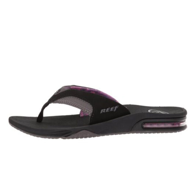 "Side view of Reef Fanning flip-flop in black and grey with purple accents (model RF001626BLG), showcasing a contoured footbed, soft fabric strap with visible stitching, and a visible air cushion heel with a bottle opener built into the outsole."